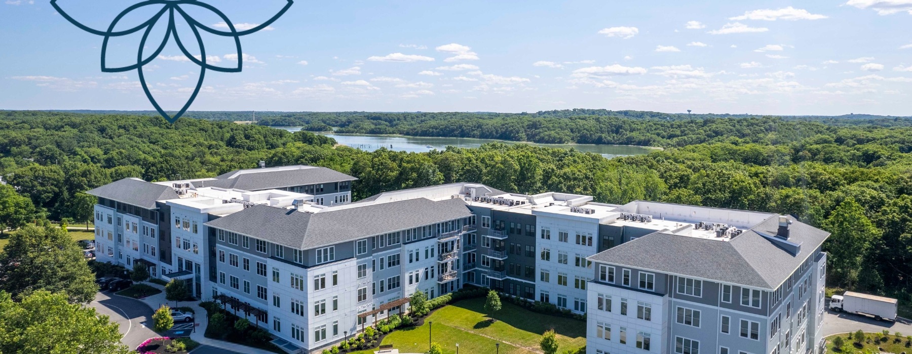 Arial view of The Cove apartment building surrounded by lush landscaping and a river in the background