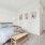 Spacious bedroom with bed, bench, side tables, and neutral decor